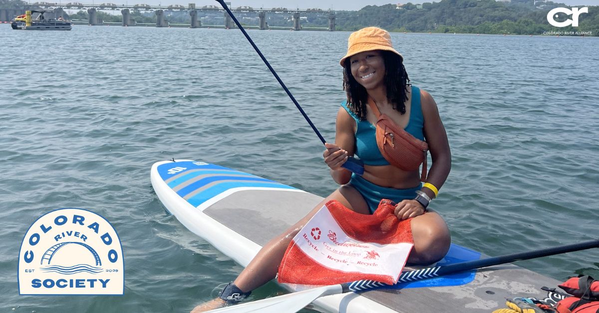 woman on paddleboard on Lake Austin volunteering to clean up trash with Colorado River Alliance