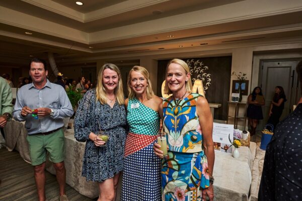 four guests smiling with drinks in hand at the cocktail reception
