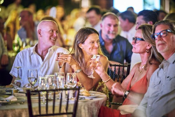 guests sharing a lively conversation over wine at a dinner table