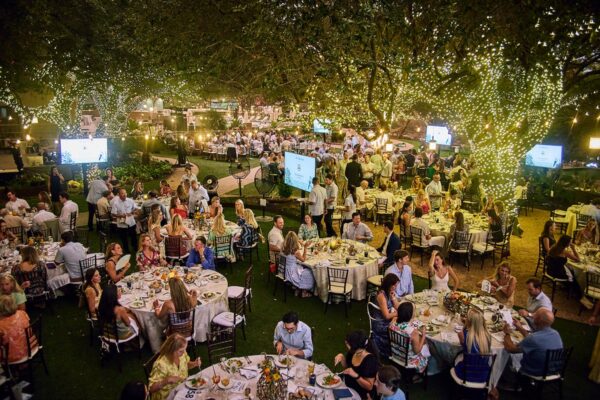 guests dining at candlelit tables under string-lit oak trees at Cocktails for the Colorado 2026